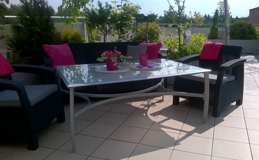 Sofa trzyosobowa i dwa fotele uzupełnione szklanym stołem